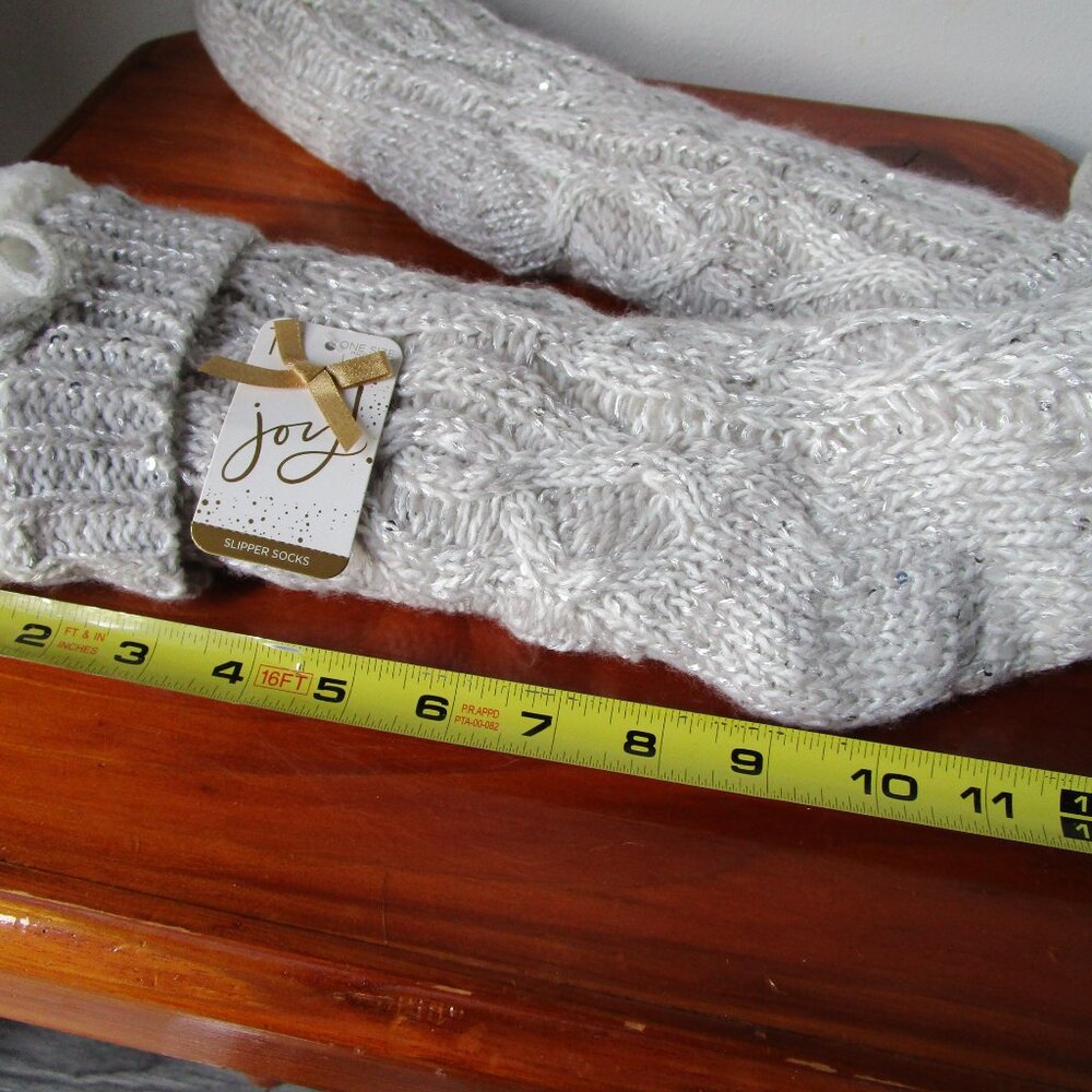 Beige slipper socks. Slip resistant bottom with tassles and lining.